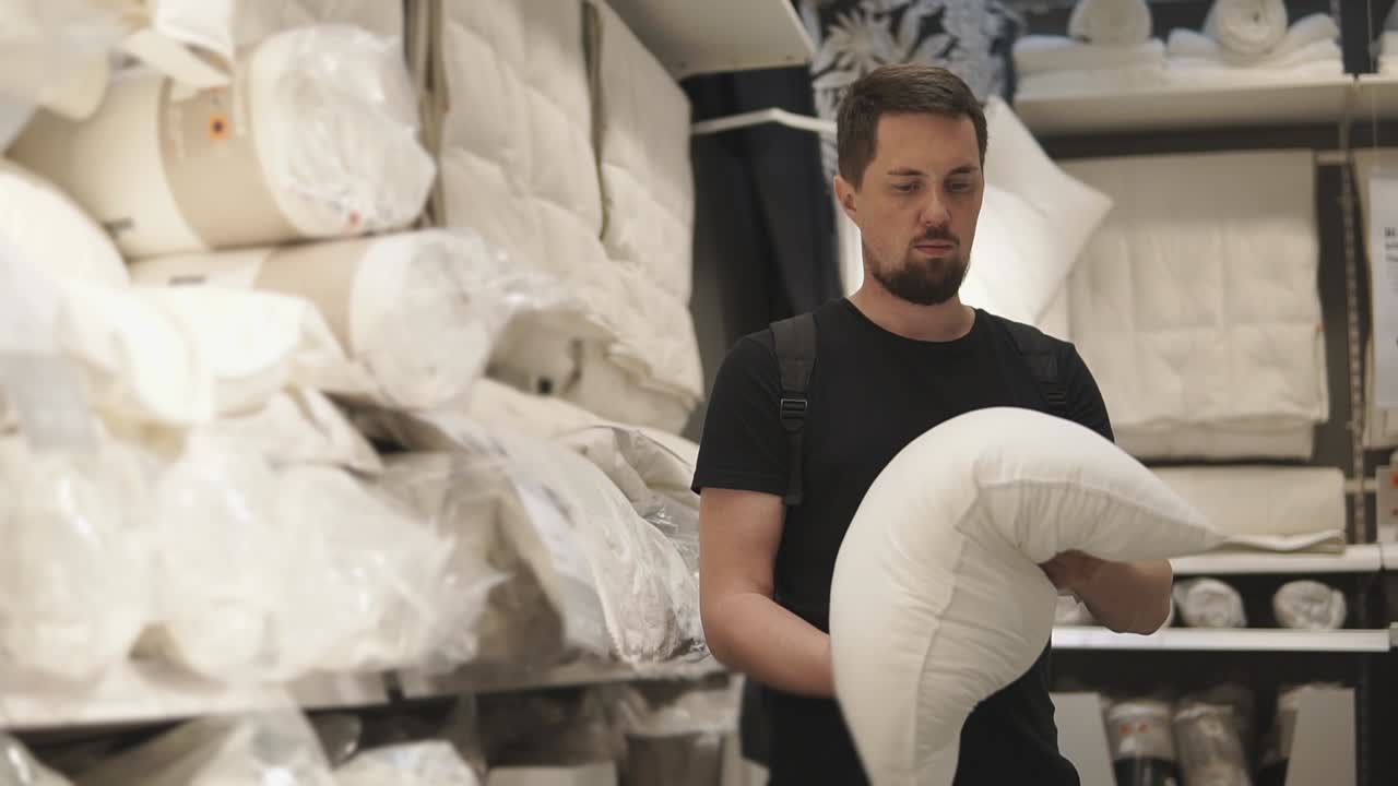 hombre comprando almohadas en una tienda de artículos para el hogar