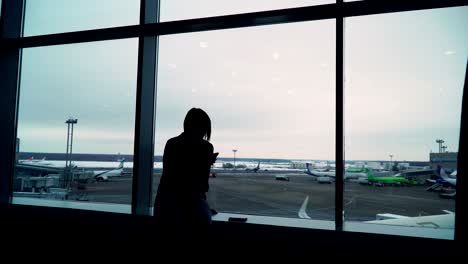 mujer en la terminal del aeropuerto esperando un vuelo