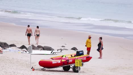 socorristas interactuando cerca de un bote de rescate en la playa