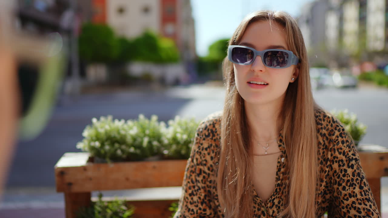 Young Woman Sitting at Outdoor Cafe