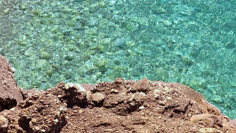 Meeresküstenhintergrund-Mit-Felsiger-Küste-Und-Lebendigem-Smaragdgrünem-Kristallwasser-Am-Morgen,-Sonnenlicht-Reflektiert-Das-Meerwasser-Im-Mittelmeer