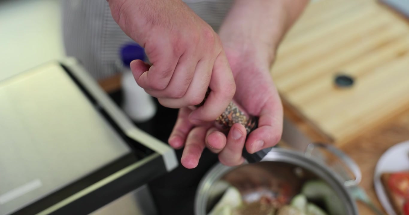 Skilled chef sprinkles fragrant mixture of spices into dish