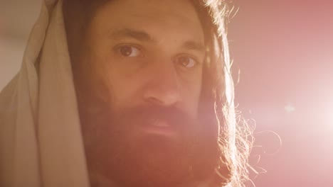 backlit portrait of man wearing robes with long hair and beard representing figure of jesus christ