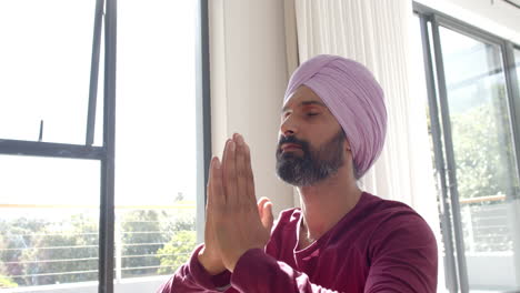 meditating, man in turban practicing mindfulness at home near window