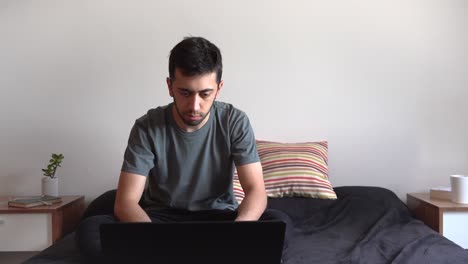 Young-man-working-from-his-laptop-on-his-bed