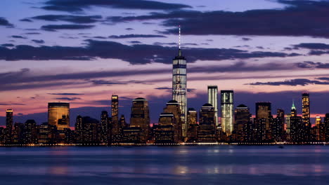 new york city skyline at dusk with one world trade center and hudson river