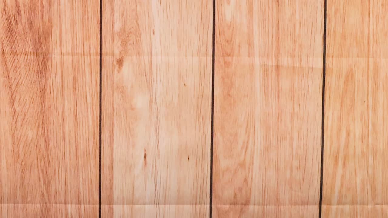 A yellow ball bounces across vertical wooden panels, showcasing dynamic motion and interaction.