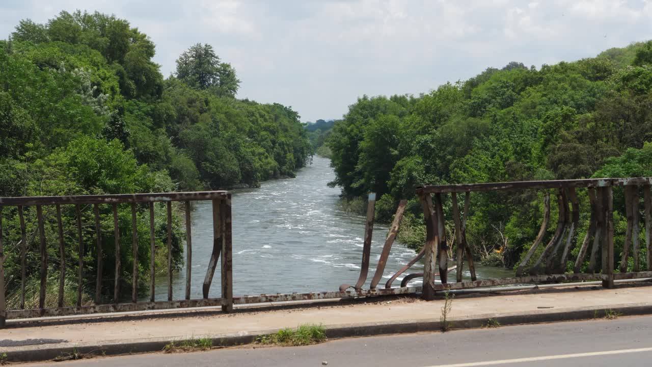 barrera de acero doblada y retorcida en el puente sobre el río cocodrilo inundado