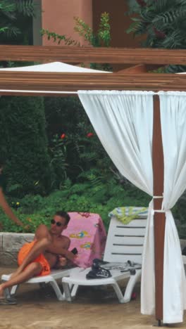 people sitting by the poolside of a resort swimming pool