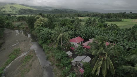 Vuelo-Aéreo-Sobre-Casa-Tropical-En-Asia-Palmeras-Pueblo-étnico