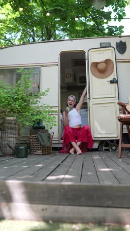 woman relaxing in a vintage trailer on a wooden deck