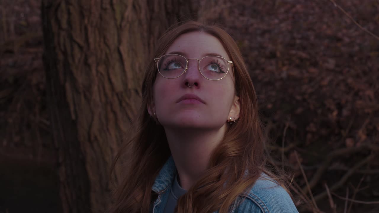Girl is looking around standing in the Woods