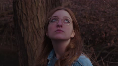 girl is looking around standing in the woods