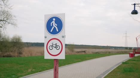 pedestrian zone sign. pedestrian walkway route sign against green promenade. no cycling road sign