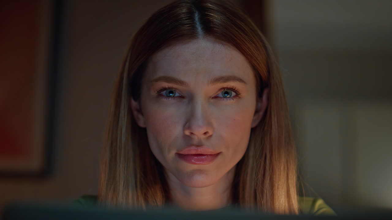 Portrait serious woman looking camera sitting dark home. Girl feeling tired