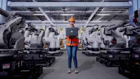Woman Engineer using Laptop in a Robotics Factory