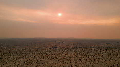 drone shot of joshua tree sunset with nearby fire and smoke creating vivid red sky