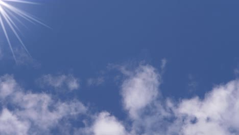 blue skies and fluffy white clouds with sun flares