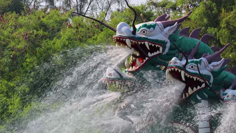 a vibrant dragon sculpture sprays water in a lush, green setting, creating a dynamic and captivating scene.