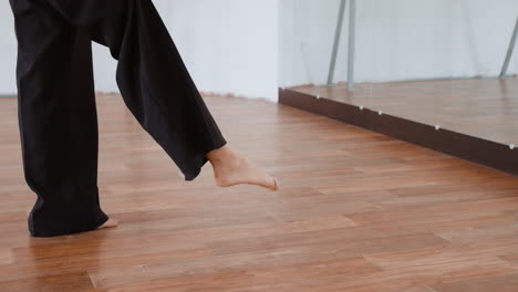 person performing leg stretch in dance studio