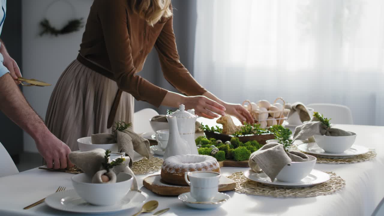 una familia caucásica preparando la mesa para la cena de pascua.