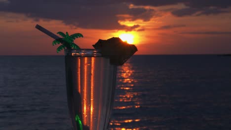 sliding shot of a cocktail at a beautiful sunset cropped