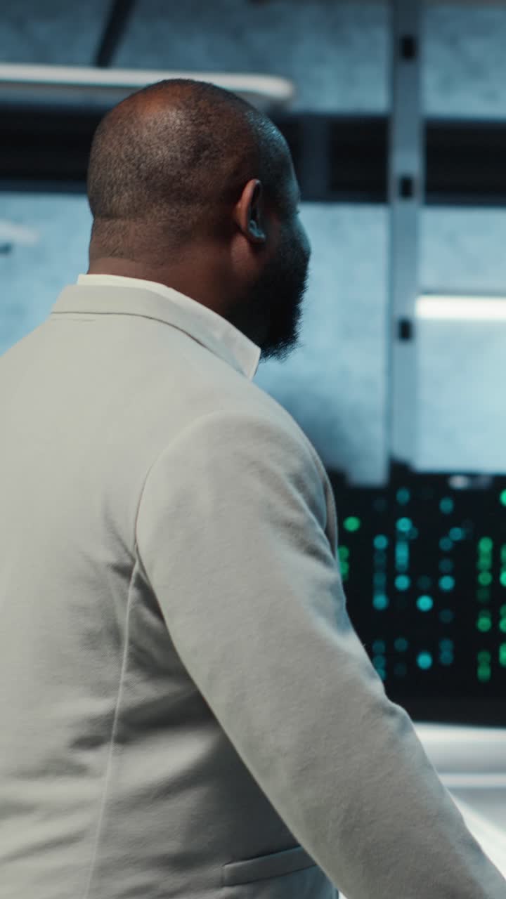 Vertical video Employee walking in high tech data center with hardware used to host websites