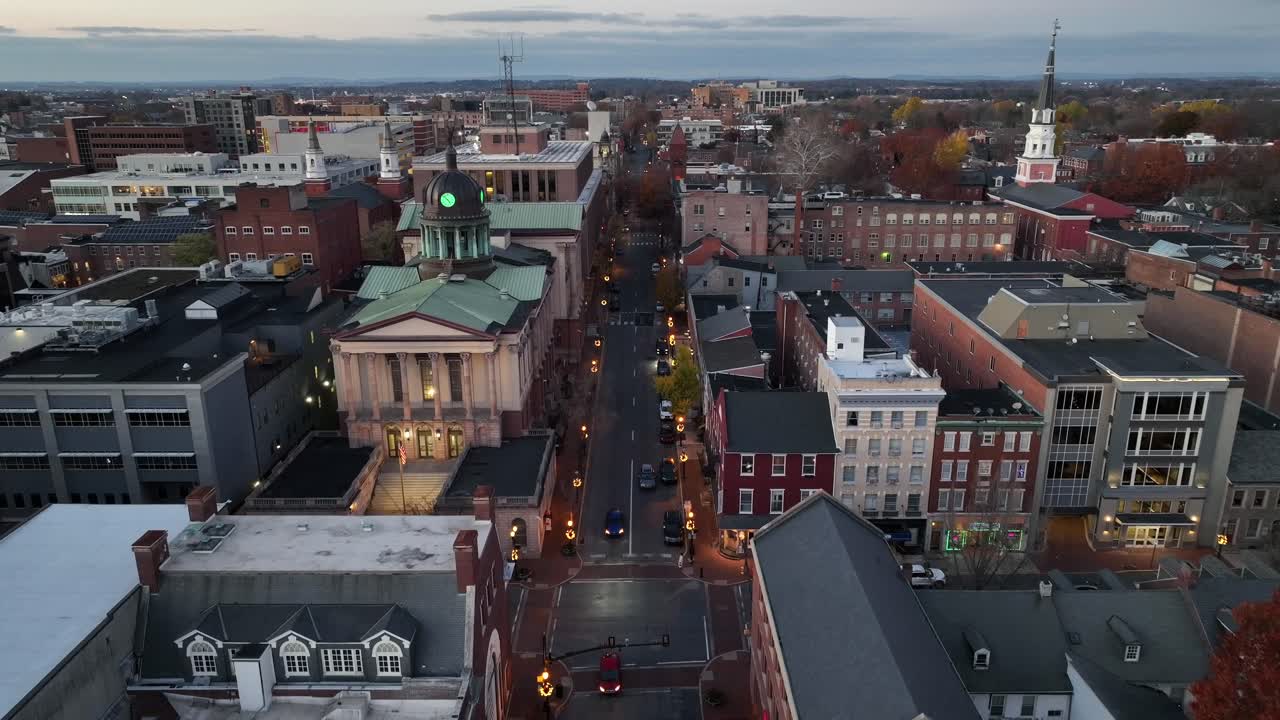 calle principal con iluminación corona de navidad en una pequeña ciudad de los ee.uu. edificio histórico de la iglesia con fila de casas. descender drone amplia toma.