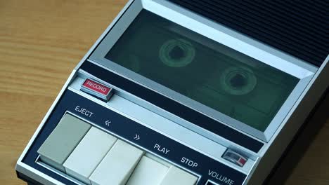cinta de cassette de audio rodando en un reproductor de época