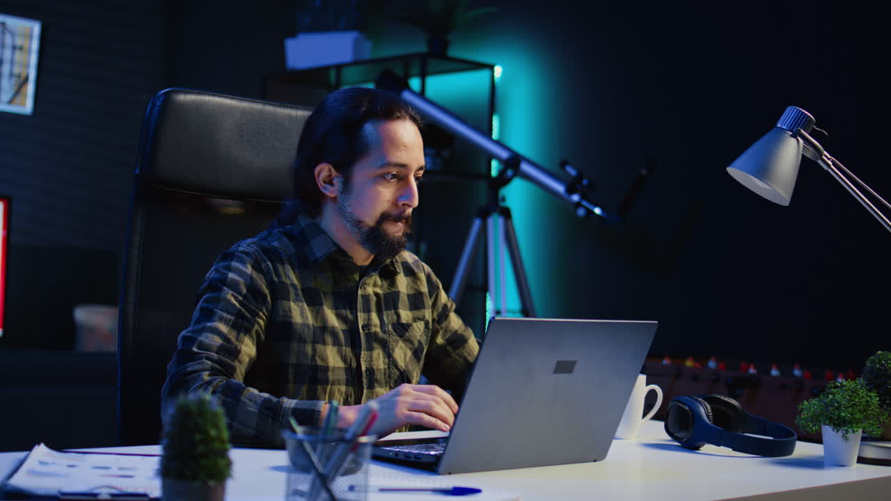 trabajador independiente enfocado que trabaja desde casa, escribiendo en una computadora portátil