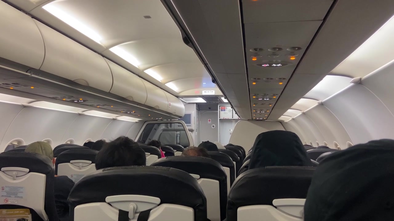 Interior da Cabine de Avião com Passageiros Sentados Antes da Decolagem