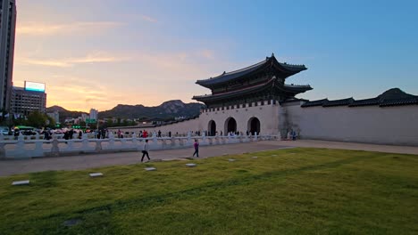 tourists at gwanghwamun gate of gyeongbokgung palace in seoul at sunset - pan shot