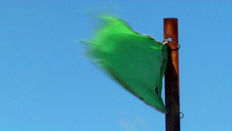 a green flag blows in the wind