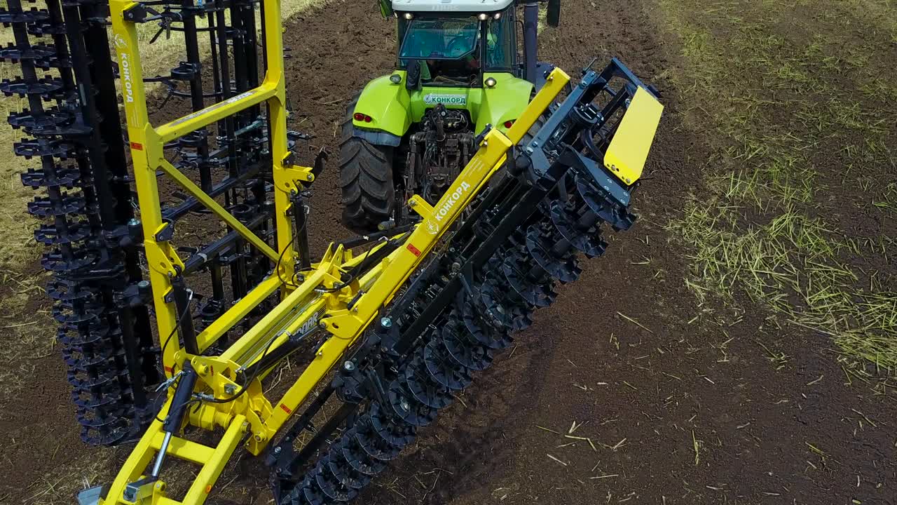 Tractor In The Field Plows The Land. VINNITSA, UKRAINE - JULY 2017: Modern tractor in the agricultural field plowing land