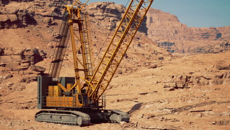 heavy machinery operates in rugged desert terrain during bright daylight