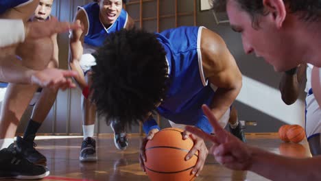 Diverse-male-basketball-team-wearing-blue-sportswear-and-doing-push-ups