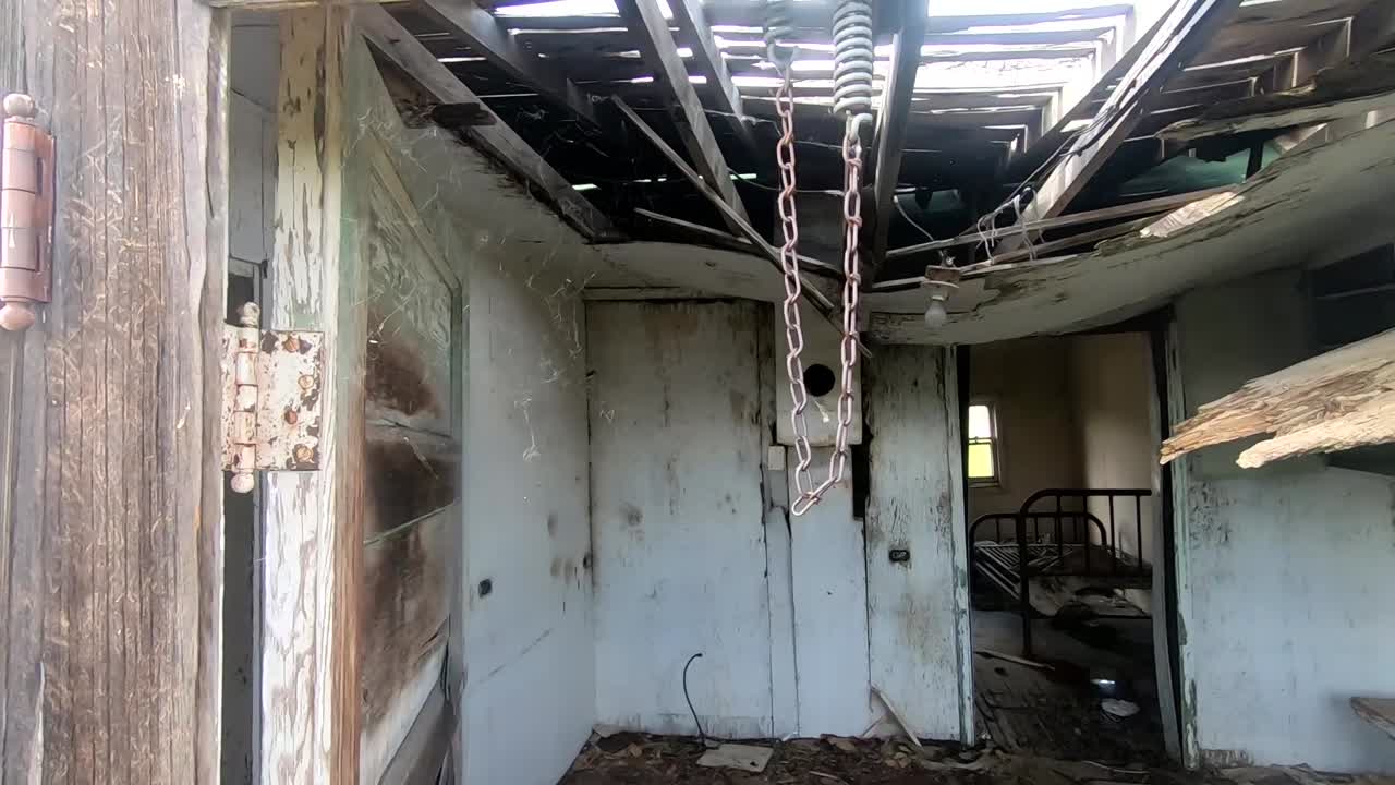 Looking into a window in a old abandoned wooden house in the country.