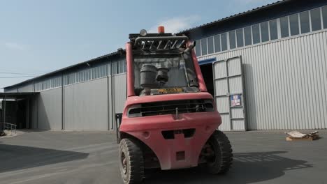 forklift driver loads rolls of steel sheet. industrial warehouse with rolls of steel sheet