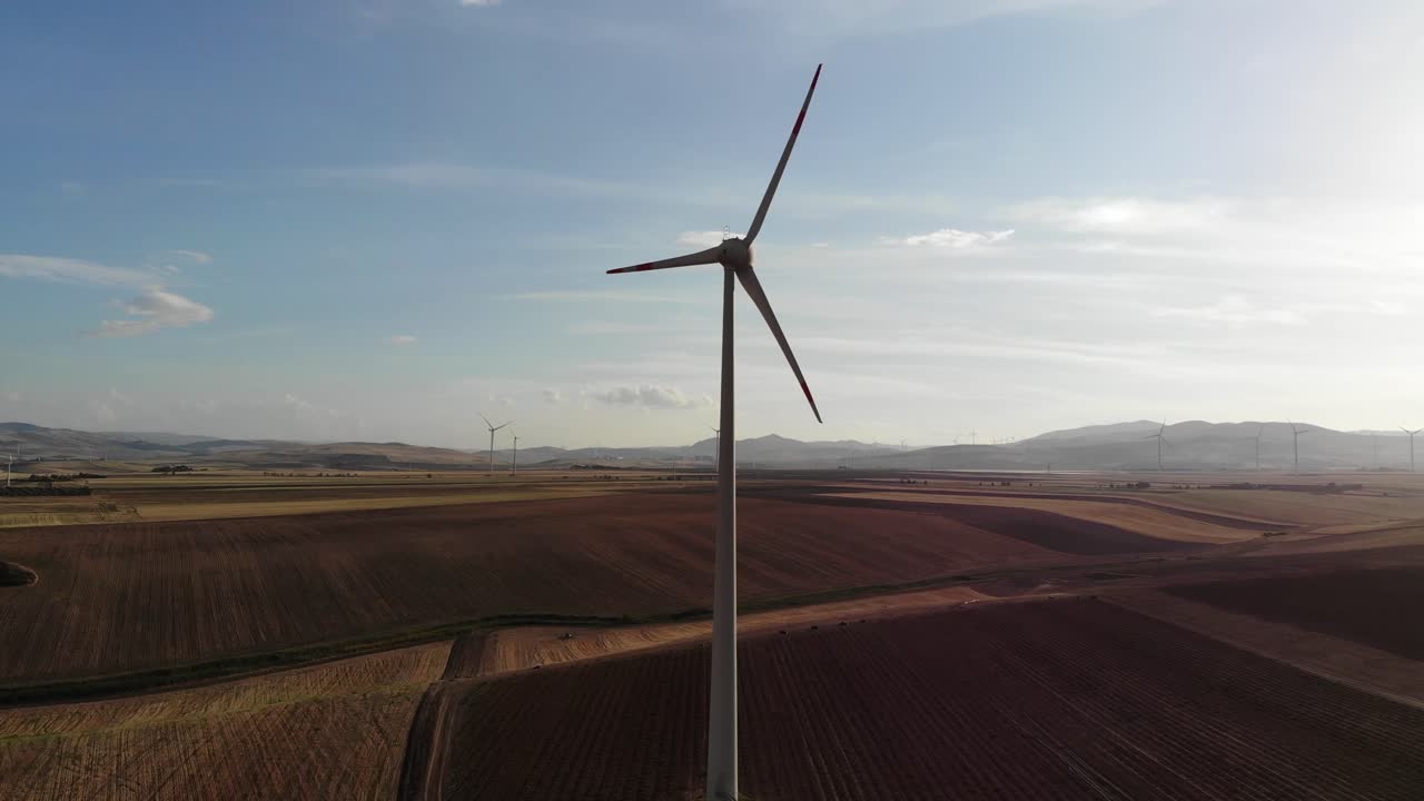 Drone lift up near a wild turbines reaching the top height during sunset in Daunia