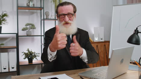 happy business man looking approvingly at camera showing thumbs up, like positive sign, good news