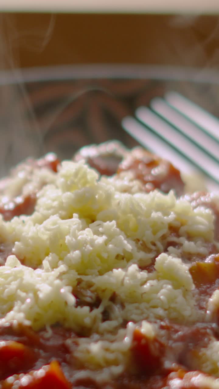 Yeni hazırlanmış bir tabak spagetti bolonezden yükselen buharın yakın çekim, ağır çekim görüntüsü. Restoran tanıtımları veya yemek belgeselleri için mükemmel. Dikey video 9:16 formatında. Sosyal medya videoları için ideal.