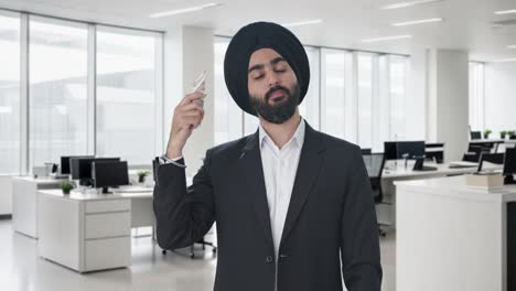 egoistic sikh indian businessman using money as fan