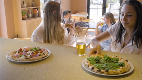 Vista-Frontal-De-Mujeres-Bebiendo-Y-Hablando-Mientras-Están-Sentadas-En-Un-Restaurante-Bar-1