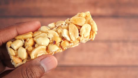 hand holding a piece of peanut brittle