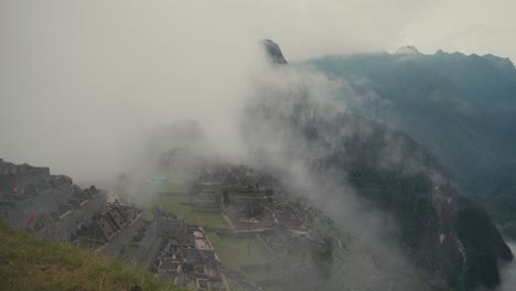 foggy clouds over historical and natural sanctuary of machu picchu in urubamba, cusco in peru. aerial drone shot
