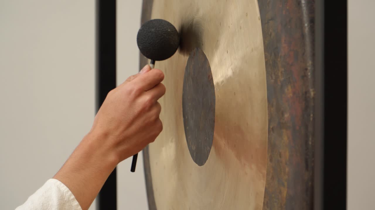 Close-up footage of musician playing Tibetan gong