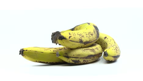 plátanos demasiado maduros aislados y girando sobre un fondo blanco