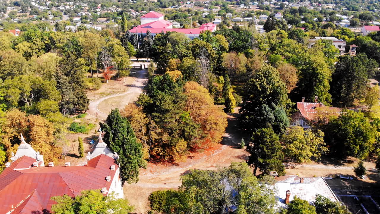 The Pommer Mansion, old abandoned building with green trees and benches on the yard. Aerial drone view. Țaul, Moldova