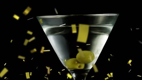 Animation-of-confetti-falling-over-cocktail-glass-with-olives-on-black-background