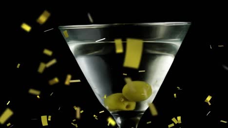 animation of confetti falling over cocktail glass with olives on black background